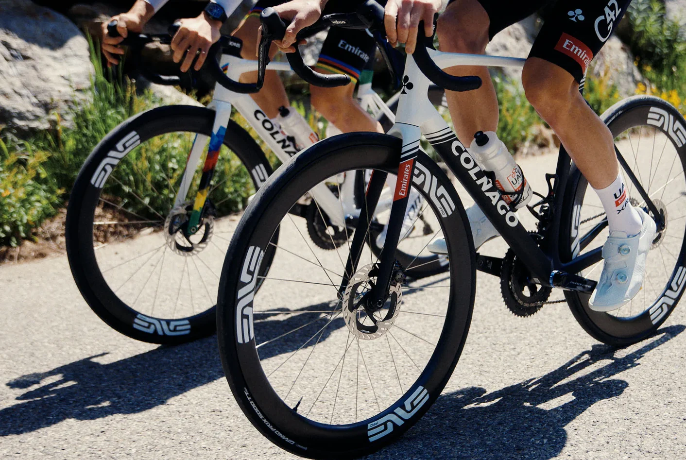 Riders on ENVE carbon wheels climbing a mountain road
