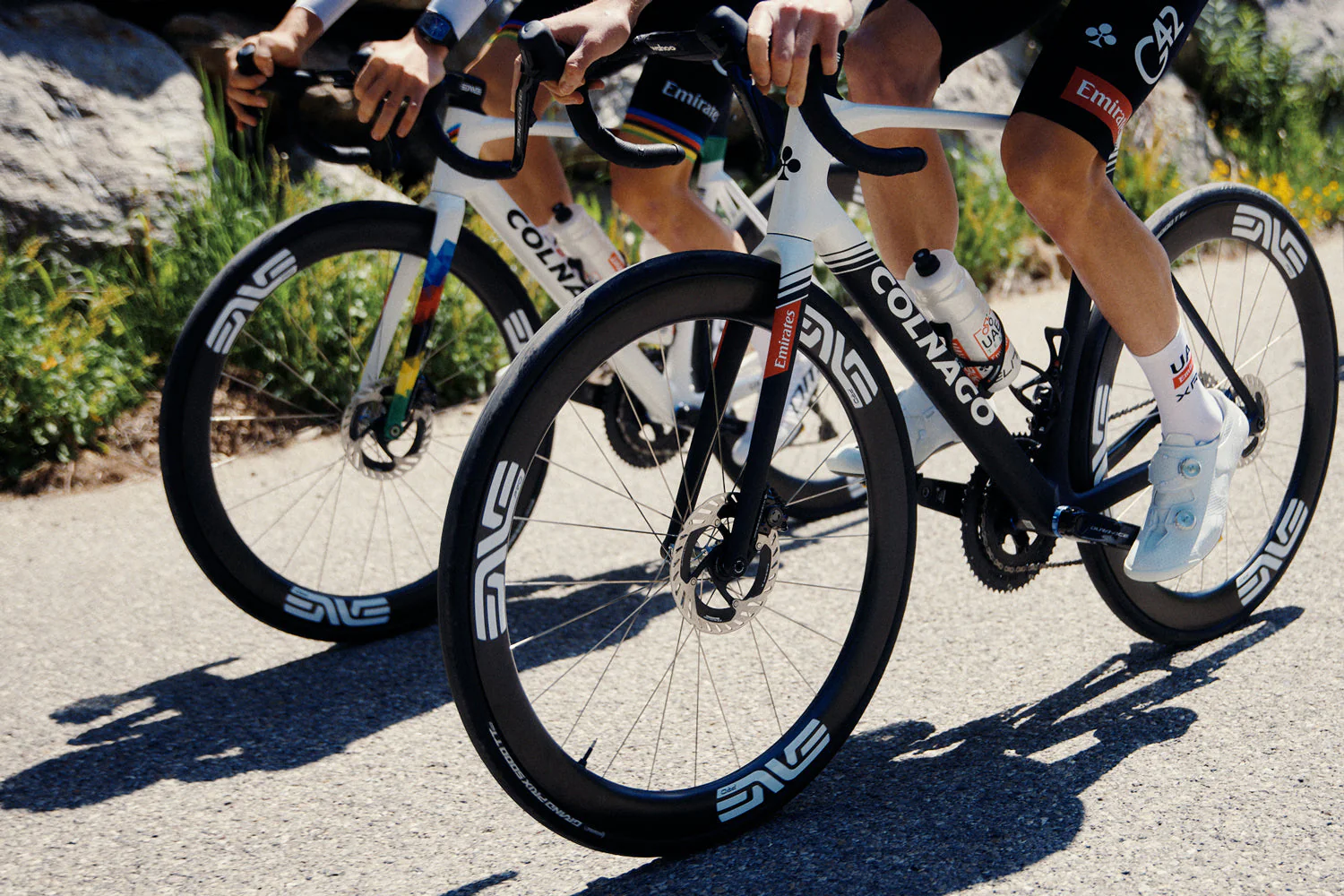 Two professional riders racing ENVE-equipped bikes on a mountain road.